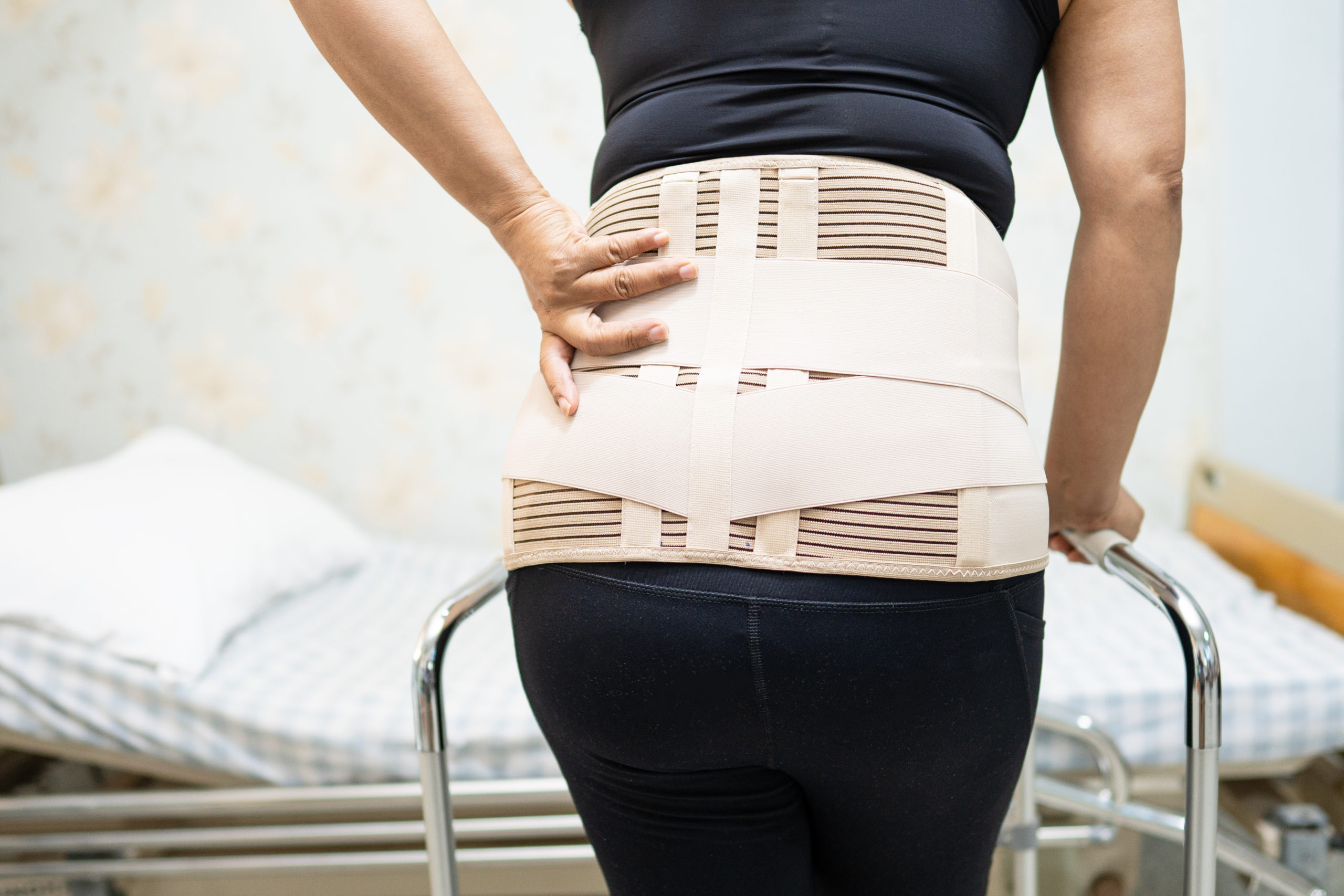 asian lady patient wearing back pain support belt for orthopedic lumbar with walker.jpg